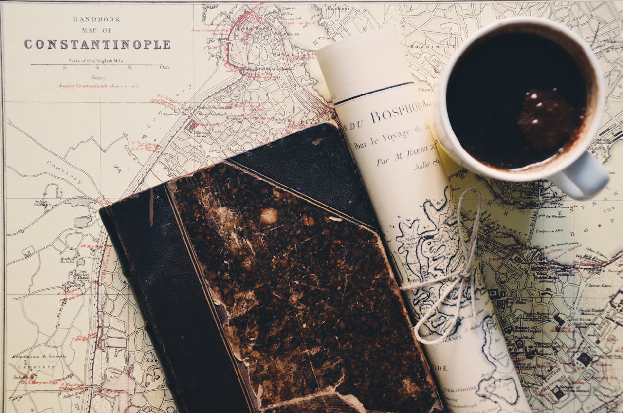 Close-up of a vintage map of Constantinople with a cup of coffee and an old notebook, conveying a travel vibe.